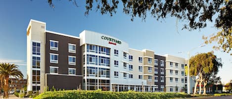 Un hôtel Courtyard by Marriott au design moderne, avec plusieurs étages et de grandes fenêtres.