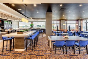 A modern hotel lobby with a bar area, seating arrangements, and large windows offering views. - Courtyard St. Petersburg Clearwater/Madeira Beach (Madeira Beach)