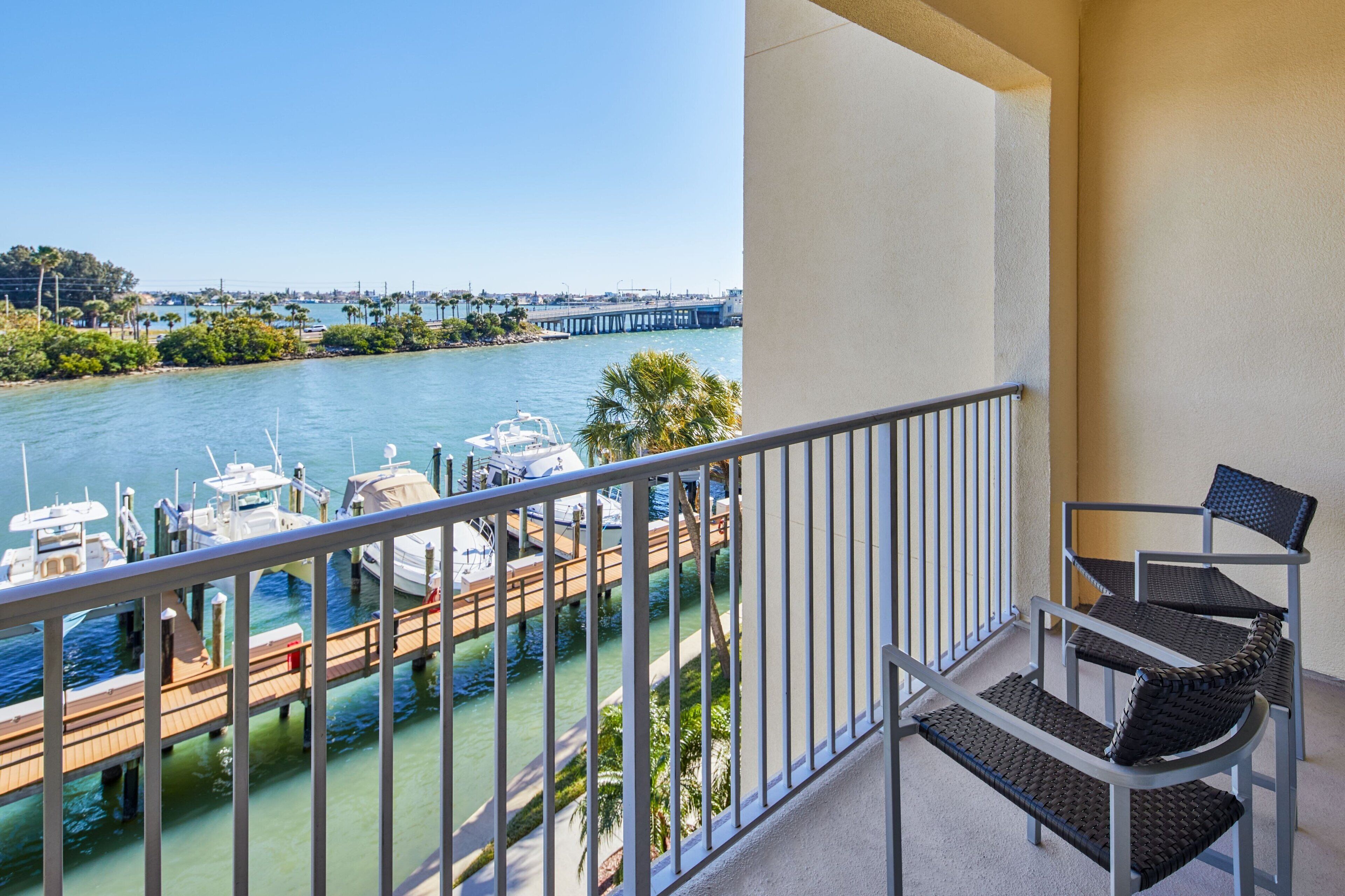 Un balcon avec vue sur une marina et un pont situé au loin.