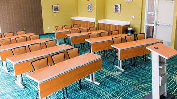 A classroom with rows of desks and chairs, a whiteboard, and a door.