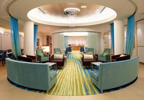 A hotel lobby with a central seating area, a reception desk, and a chandelier. - SpringHill Suites Sumter (Sumter)