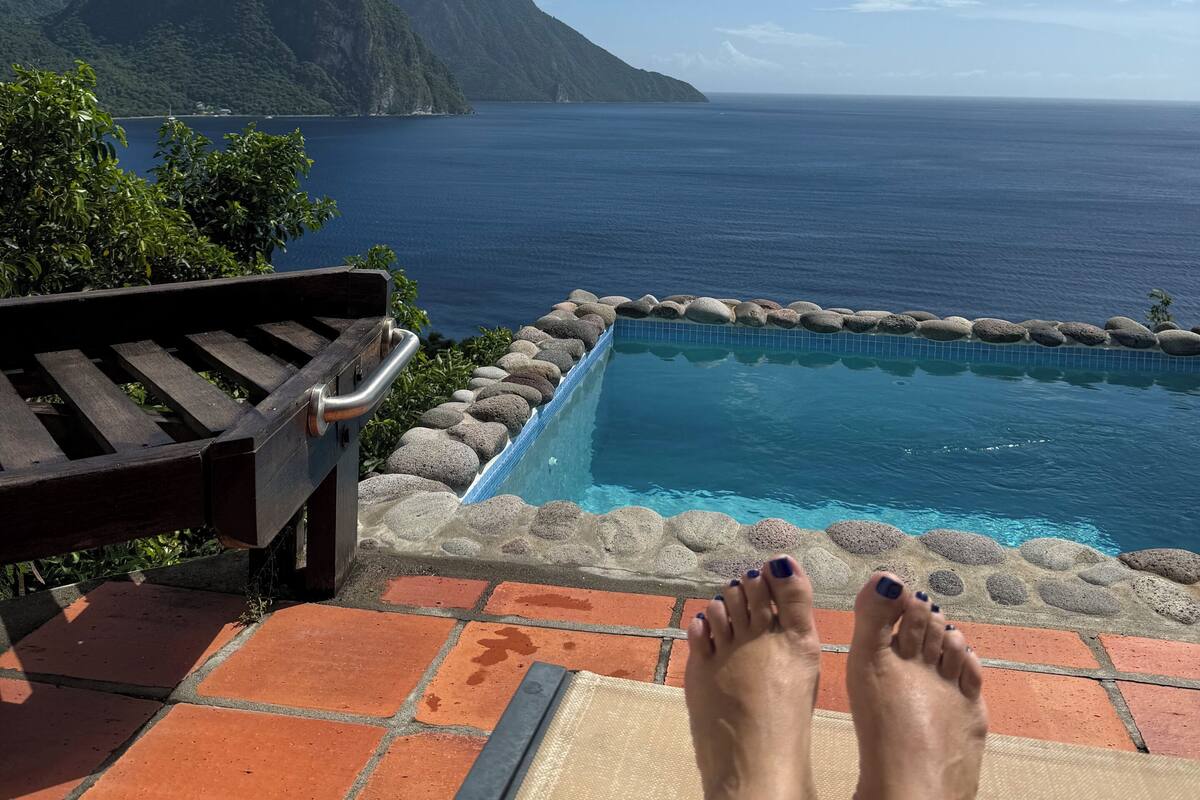 A poolside area with a view of a mountain and the ocean.