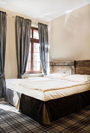 A bedroom with a large bed, curtains, a wooden headboard, and a checkered floor. - Five Stars Bed&Breakfast (Wroclaw)