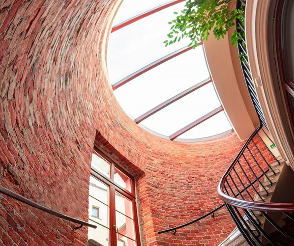A spiral staircase with brick walls and a skylight. - Five Stars Bed&Breakfast (Wroclaw)