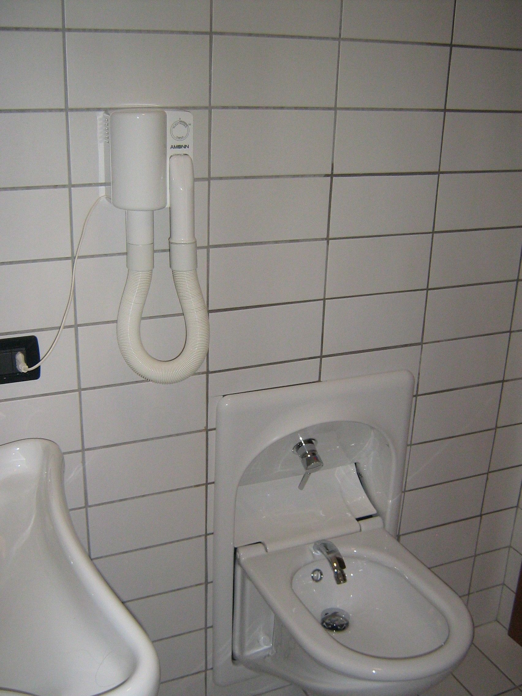 A bathroom with a urinal, a bidet, and a toilet.