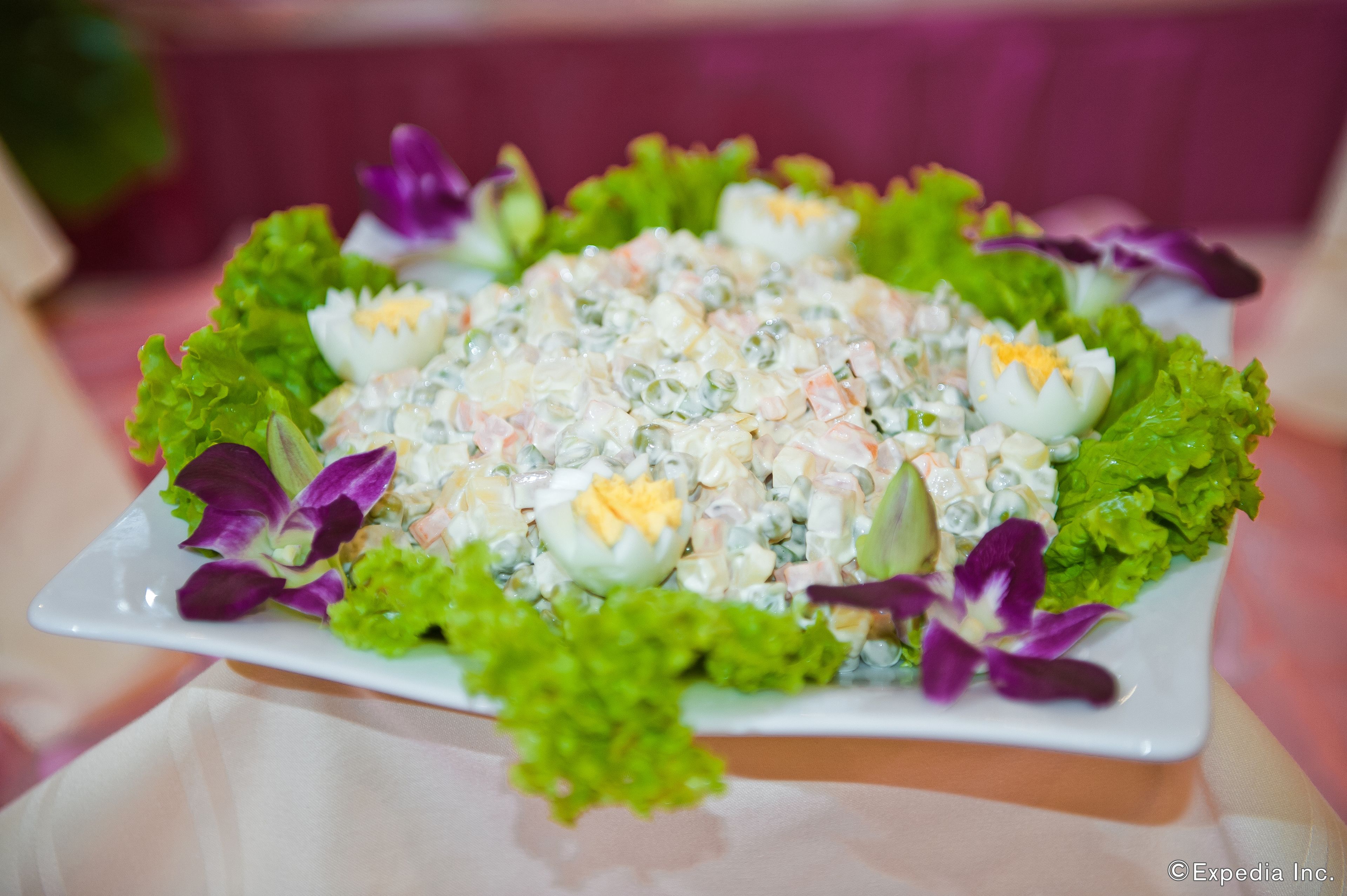 A salad with eggs and lettuce on a white plate.