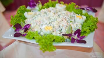 A salad with eggs and lettuce on a white plate.
