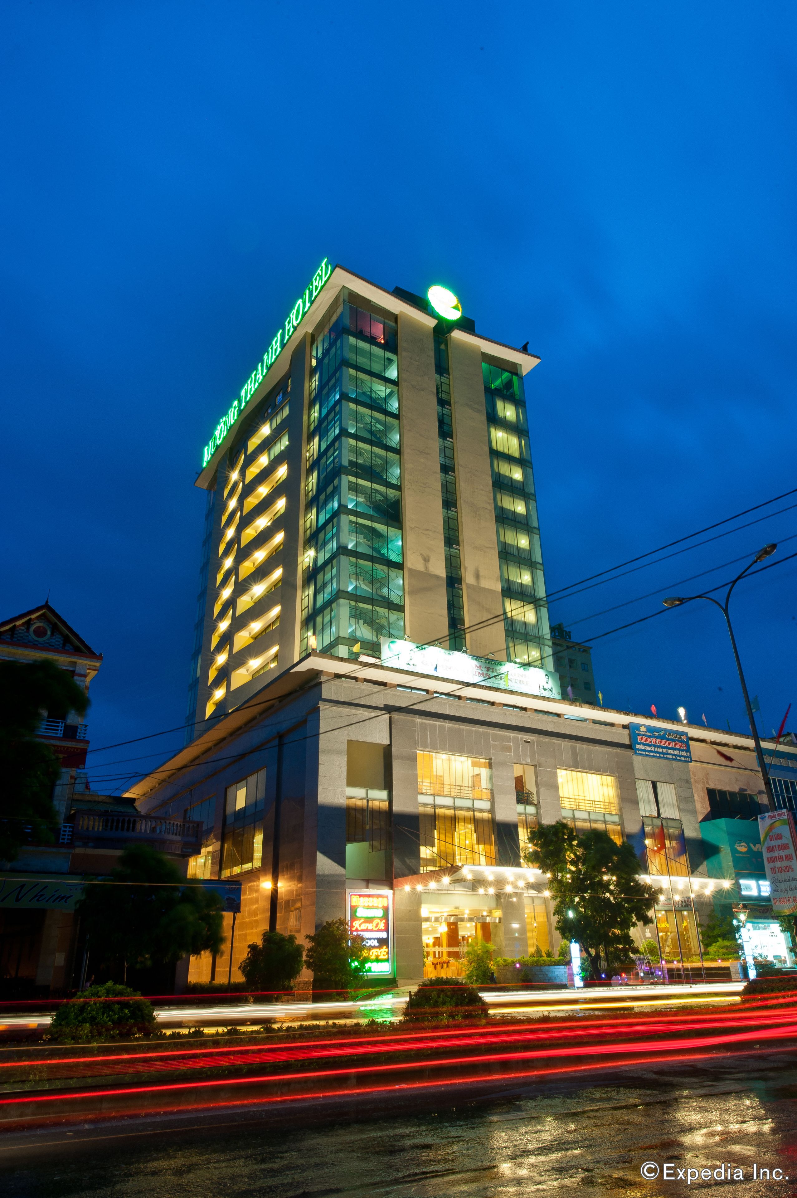A tall hotel with illuminated signage, a modern glass facade, and a well-lit entrance.