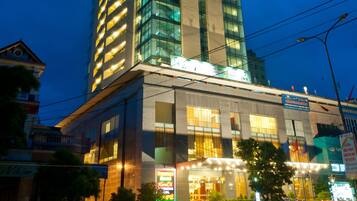 A tall hotel with illuminated signage, a modern glass facade, and a well-lit entrance.