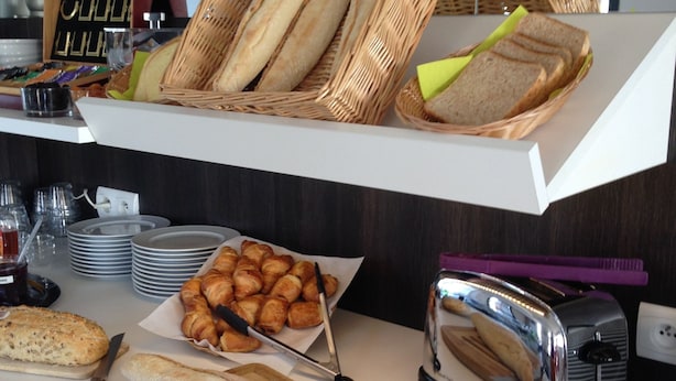 Un comptoir de buffet proposant une variété de pains, de viennoiseries et un grille-pain.