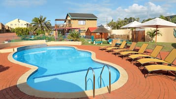 Una piscina al aire libre, sillones reclinables de piscina