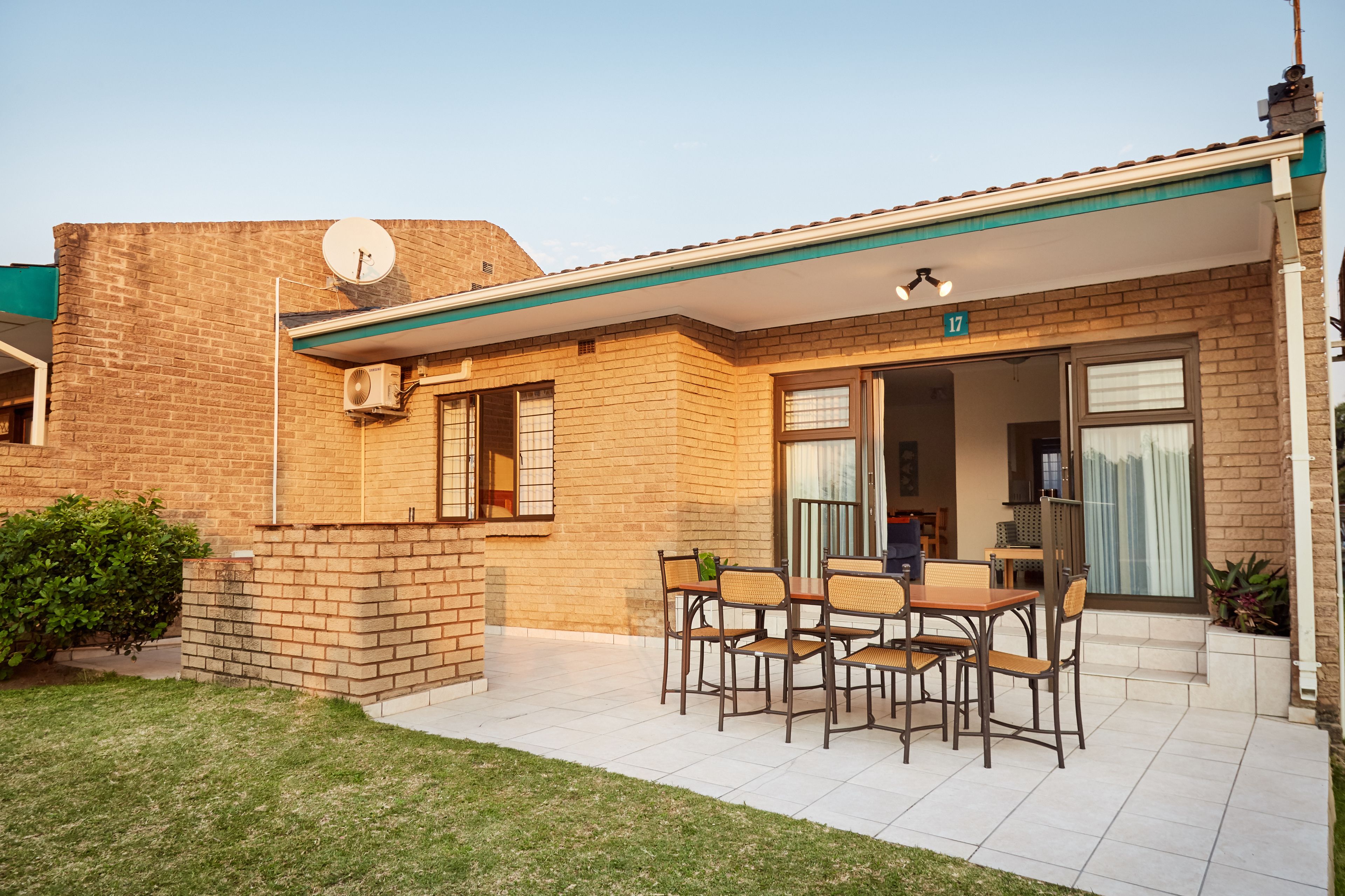 A brick building with a covered patio area featuring a table and chairs.