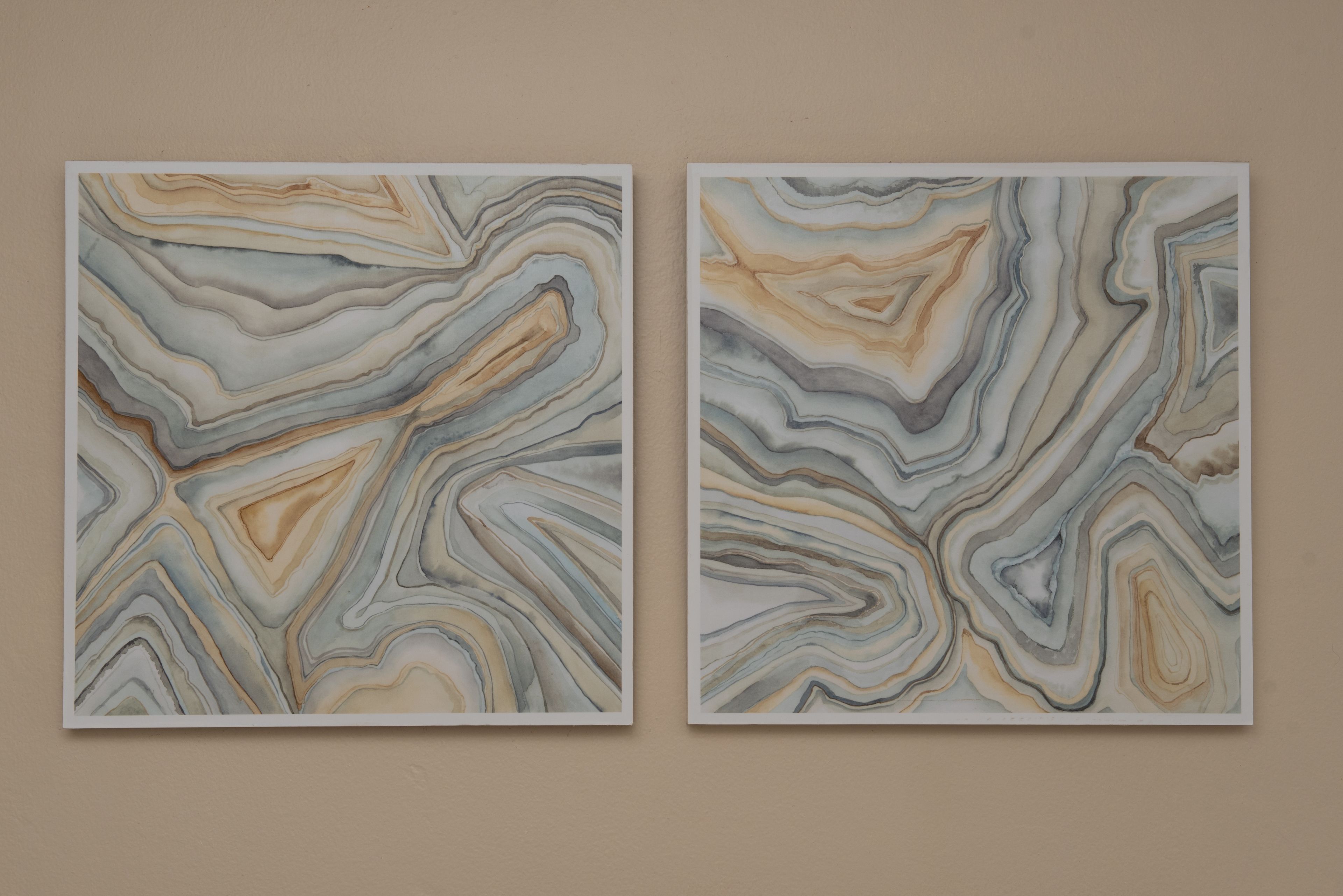 Two abstract paintings with wavy patterns and a beige wall background.