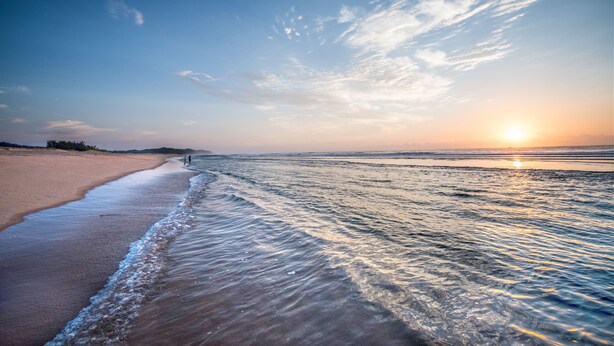 A beach with a clear sky and the sun setting on the horizon. - First Group Lake View Cabanas (St. Lucia)