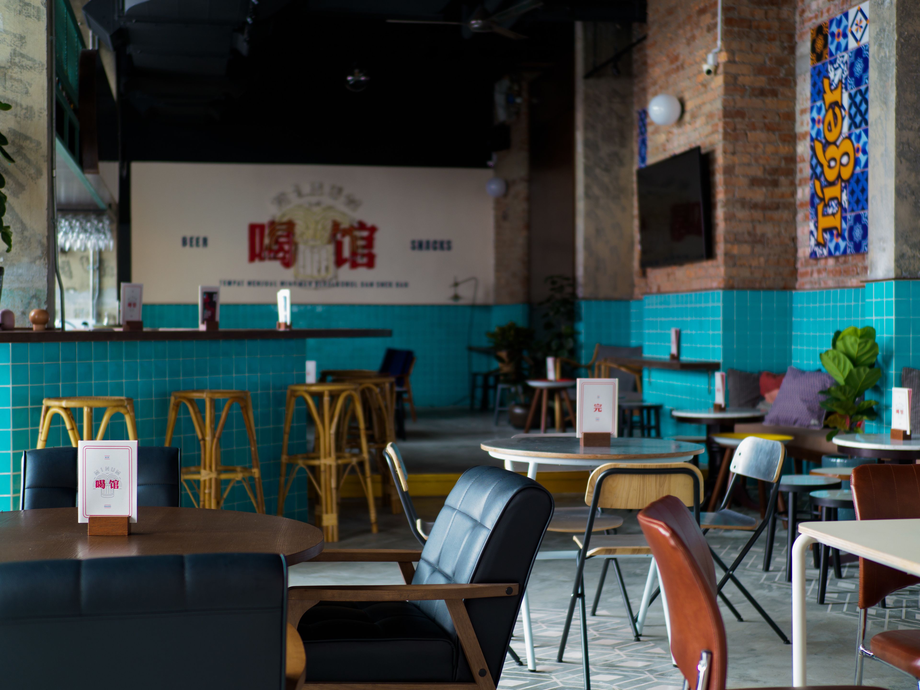 A restaurant interior with a counter, seating area, and a decorative wall.
