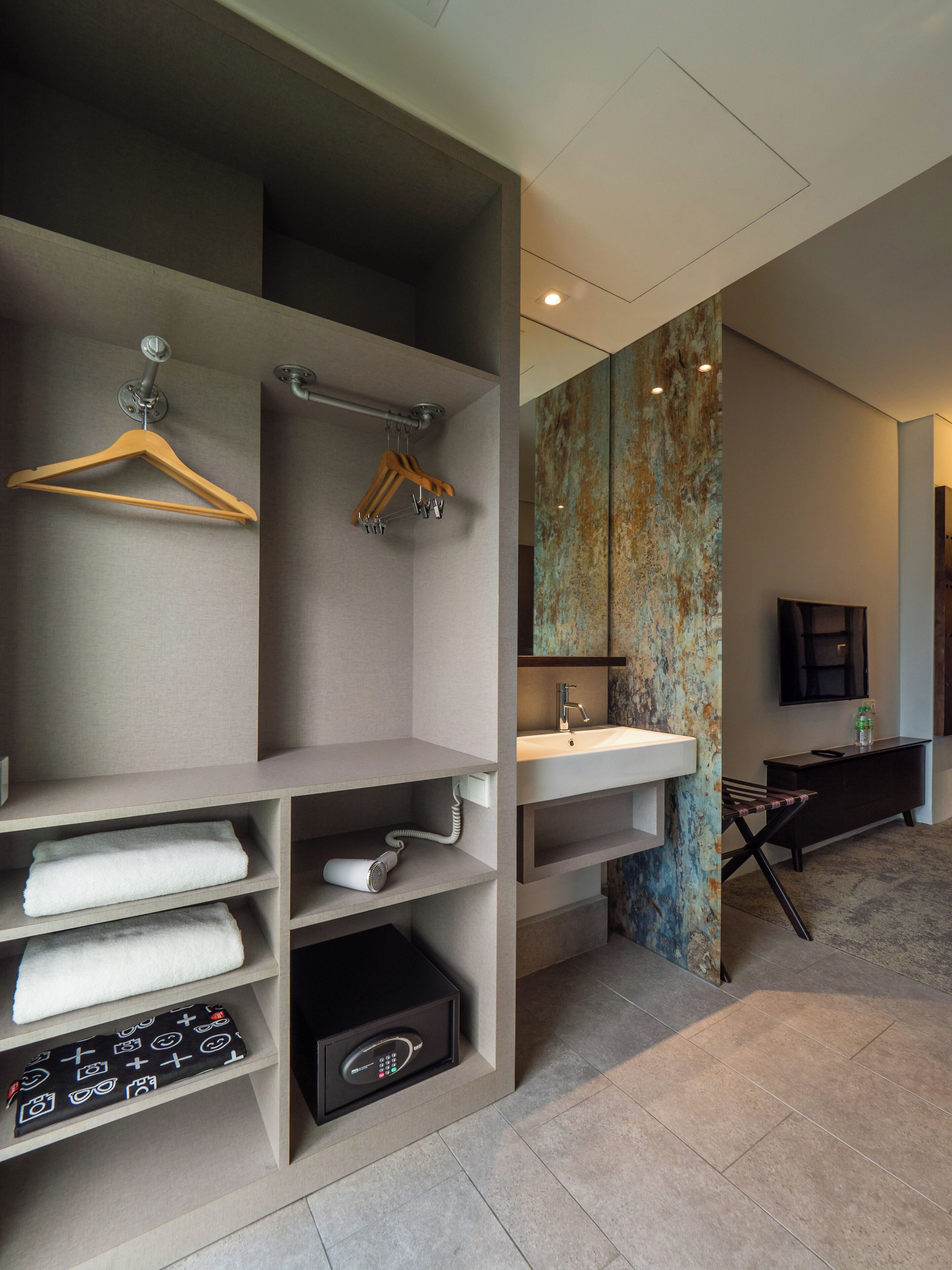 A modern bathroom with a large mirror, a sink, and a towel rack.