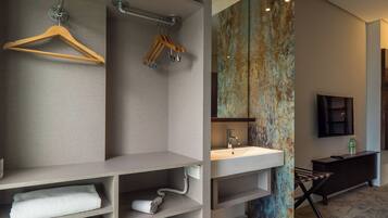 A modern bathroom with a large mirror, a sink, and a towel rack.