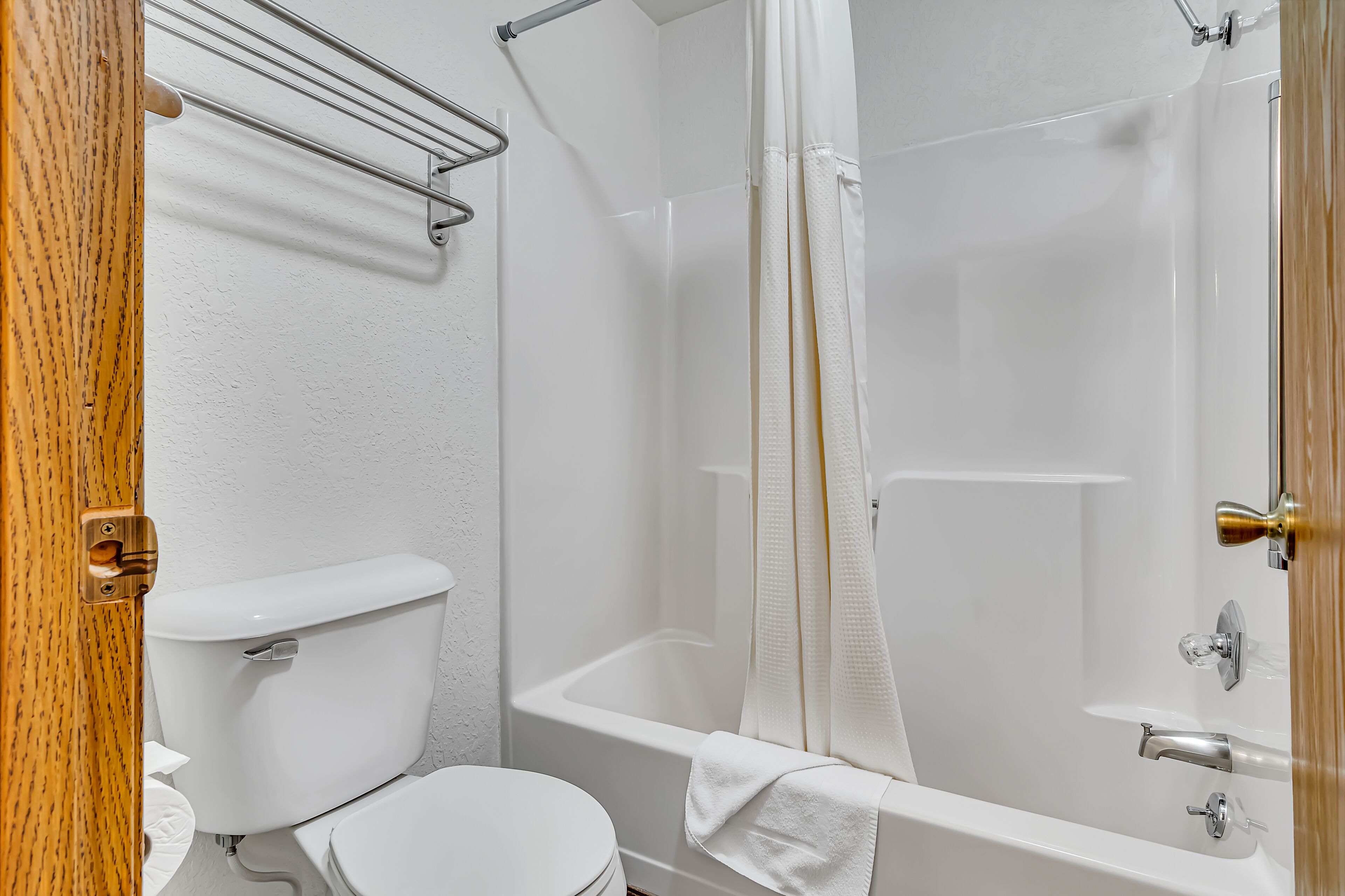 Une salle de bain équipée de toilettes, d’une baignoire et d’un rideau de douche.