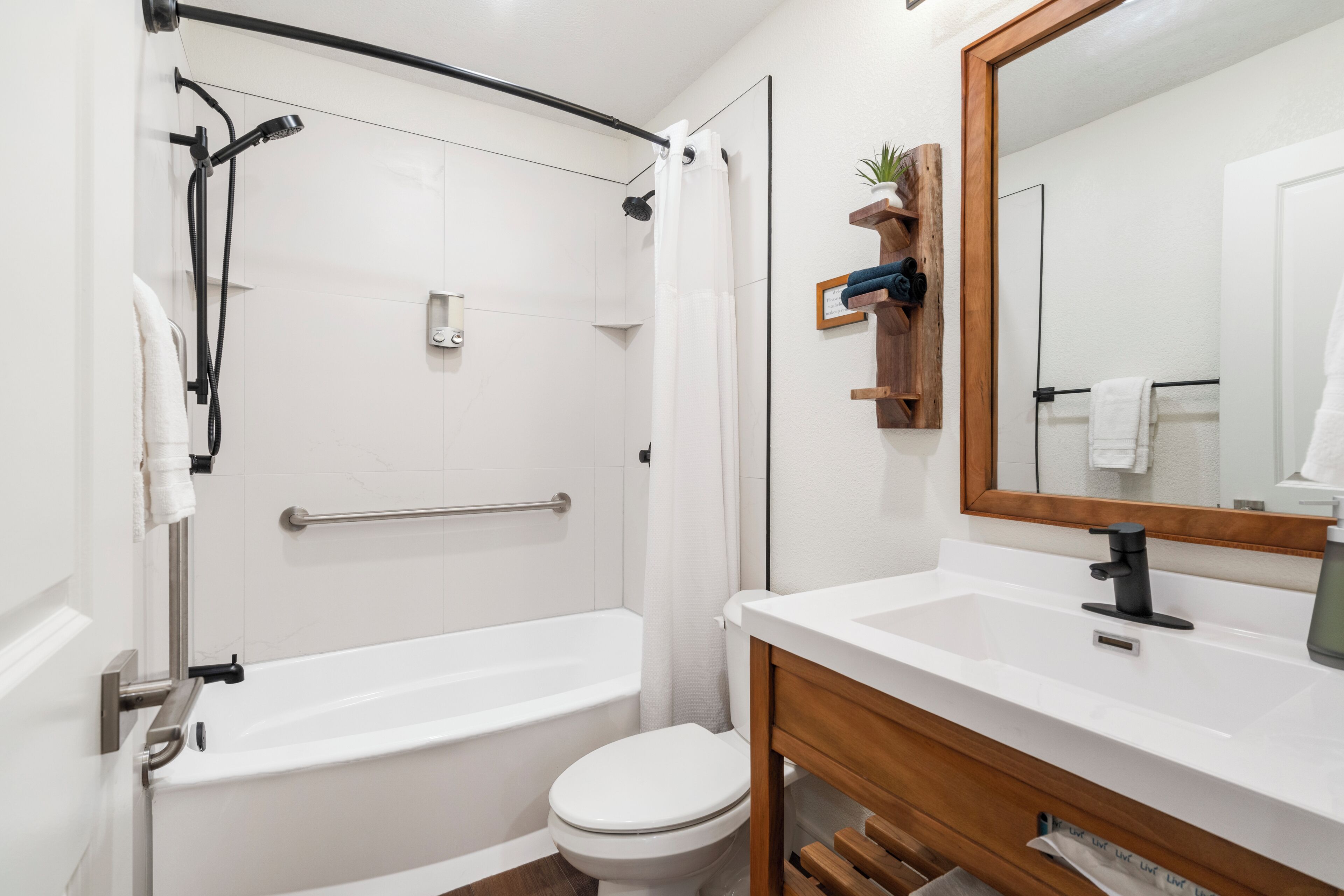 A modern bathroom with a walk-in shower, a toilet, and a vanity with a mirror.