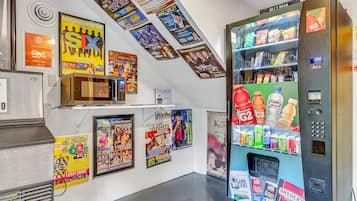 Una pared con carteles diversos y una máquina expendedora.