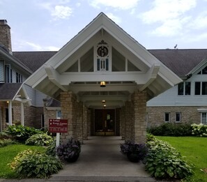 L’entrée du centre d’événements du chalet se distingue par sa façade en pierre, une horloge et une enseigne indiquant qu’il est situé à l’adresse THYME.