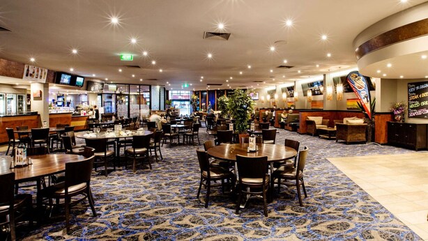 Um restaurante amplo com várias áreas de refeições, um bar e um buffet.