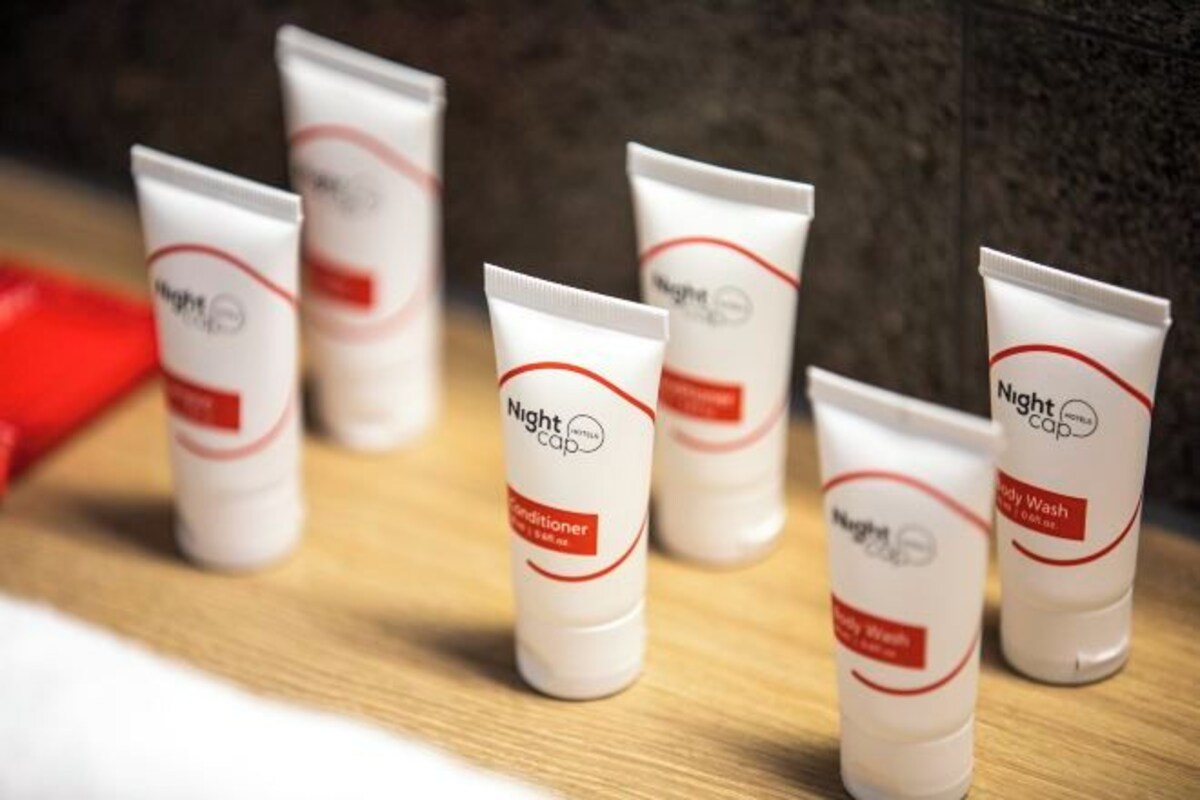 Several tubes of Nightcap body wash on a wooden surface.