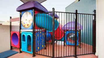 Children can play safely in this enclosed area with a slide, climbing elements, and tunnel.