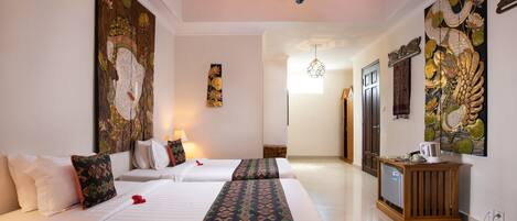 A hotel room with two beds, a wooden cabinet, and artwork on the walls.