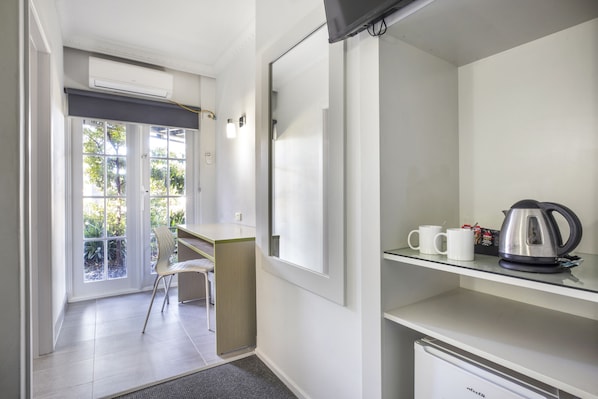 A modern kitchen with a built-in refrigerator, a coffee maker, and a kettle on the countertop.
