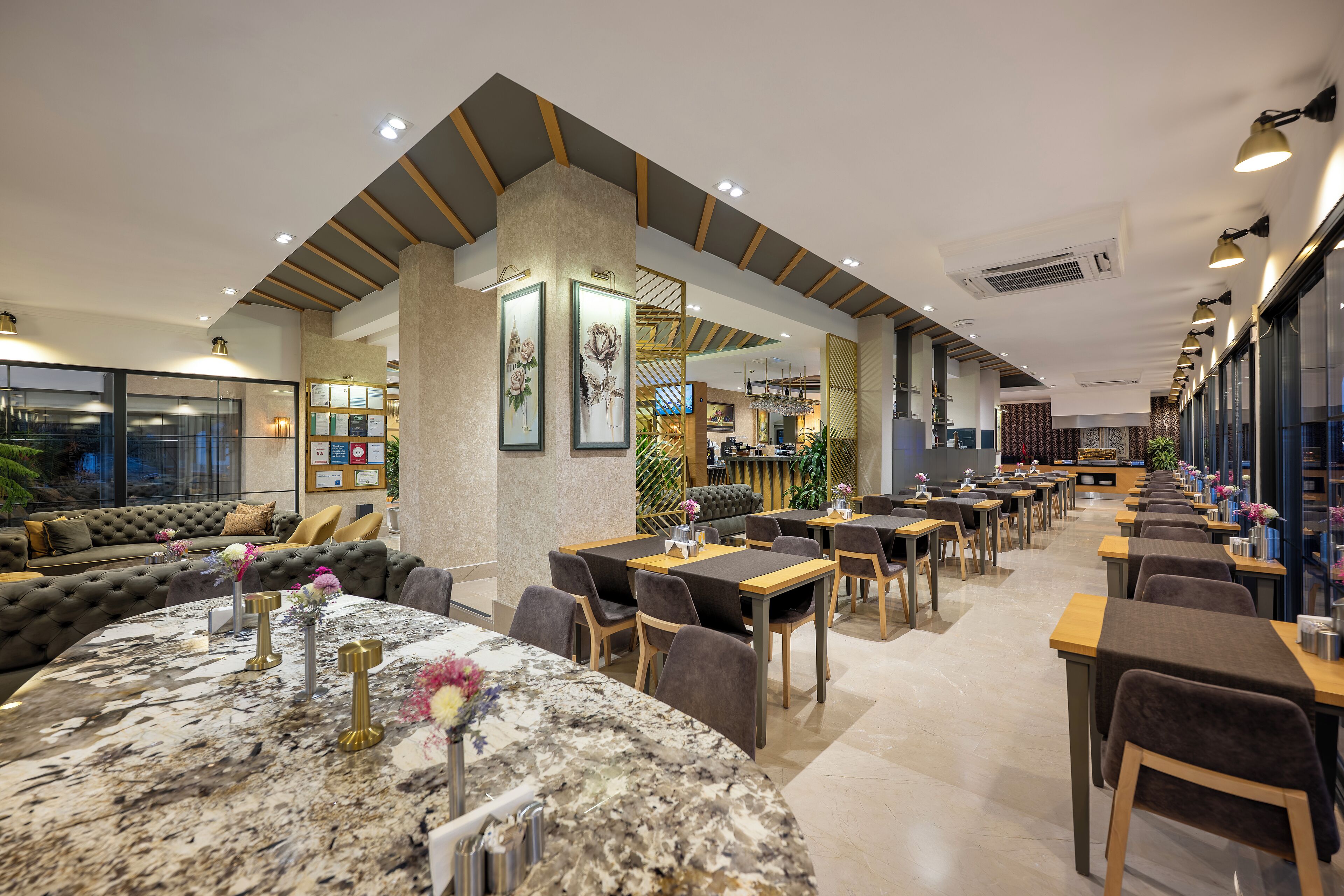 Un restaurante moderno con barra de mármol, asientos acolchados y una amplia sala de comedor con mesas y sillas.