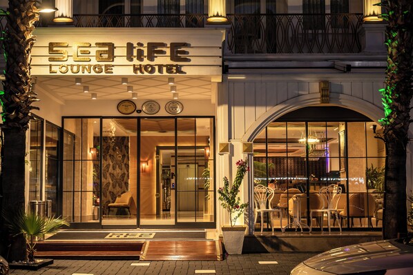 The exterior of the Sea Life Lounge Hotel with a well-lit entrance, large glass doors, and a visible seating area inside. - Sealife Lounge Hotel - Adult Only (Konyaalti)
