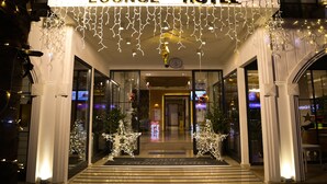 The exterior of Sea Life Lounge Hotel with illuminated signage, decorative lights, and a Christmas tree.