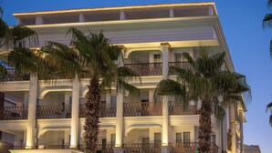 A multi-story hotel with a grand entrance, palm trees, and a sign reading "Sea Life Lounge Hotel".