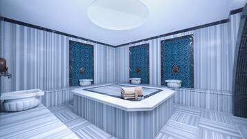 A modern bathroom with a central jacuzzi, striped marble walls, and decorative blue tiles.