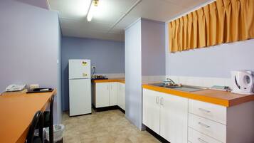 A compact kitchen with a refrigerator, sink, and a small countertop.