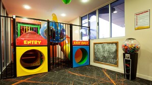 A play area with colorful slides and a gumball machine. - Vale Hotel (Aitkenvale)