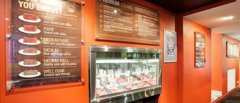 A meat display with various cuts and a menu describing meat doneness levels.