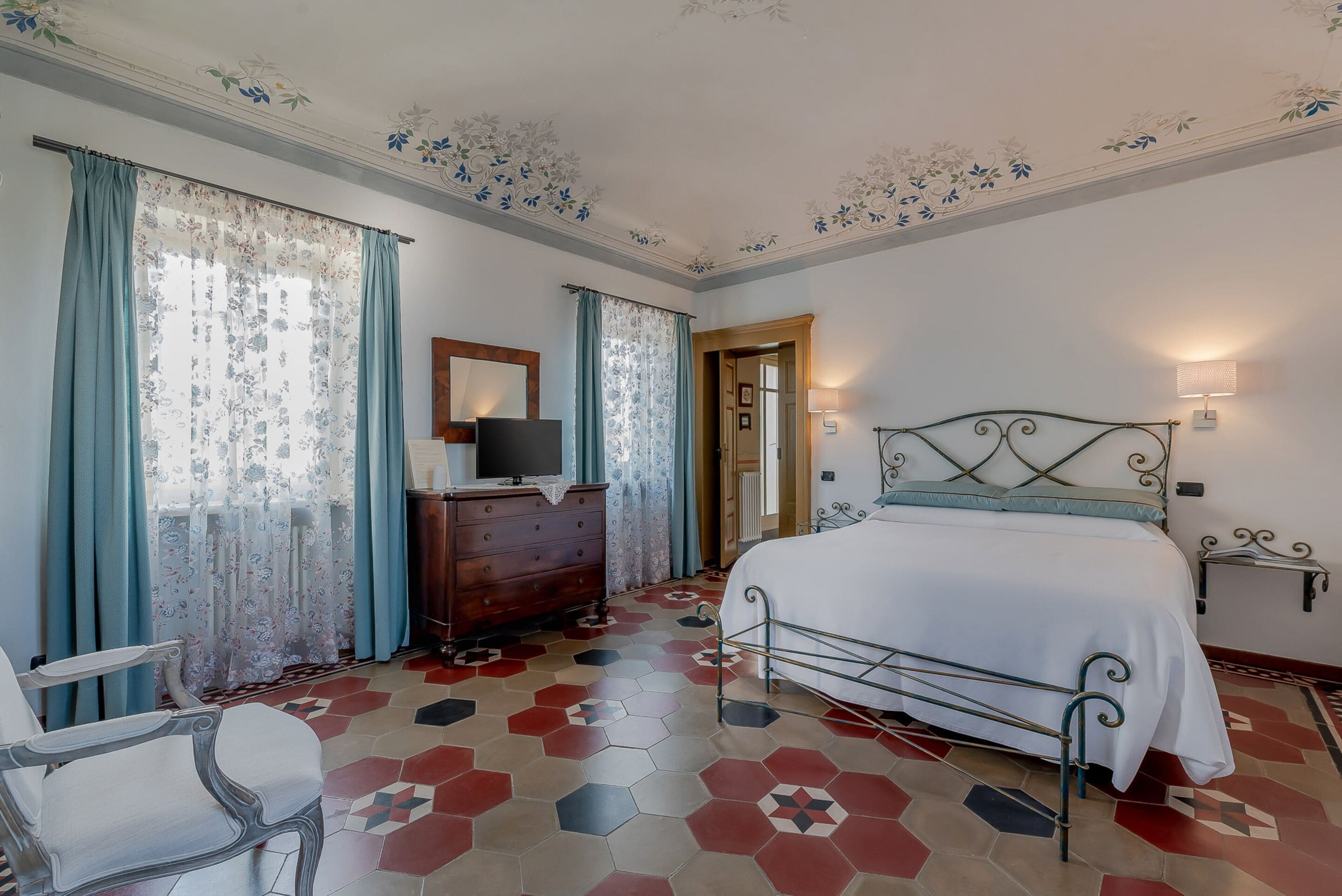 Une chambre à coucher avec un lit, une commode, une chaise et un miroir.