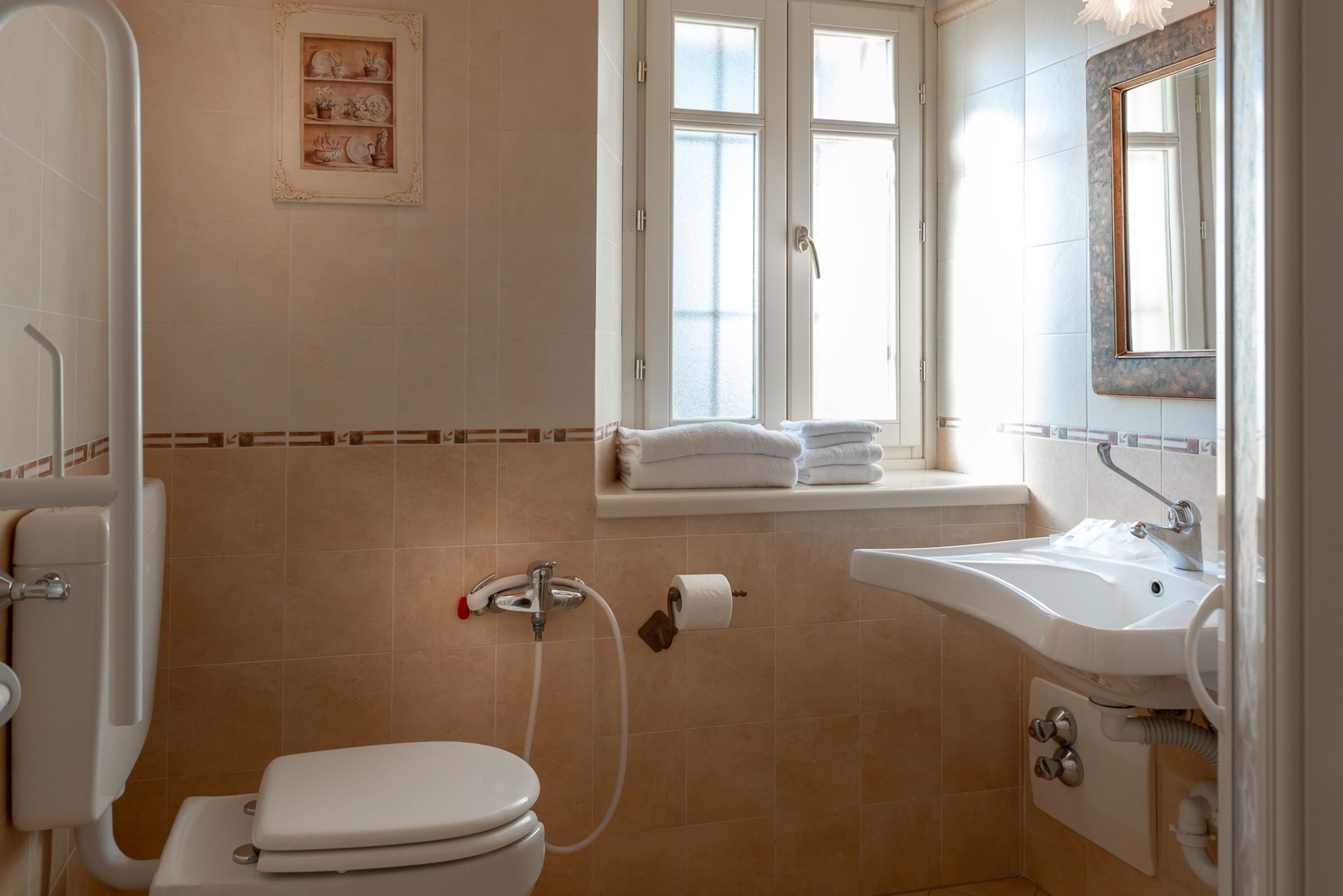Un baño con inodoro, lavamanos y ventana.