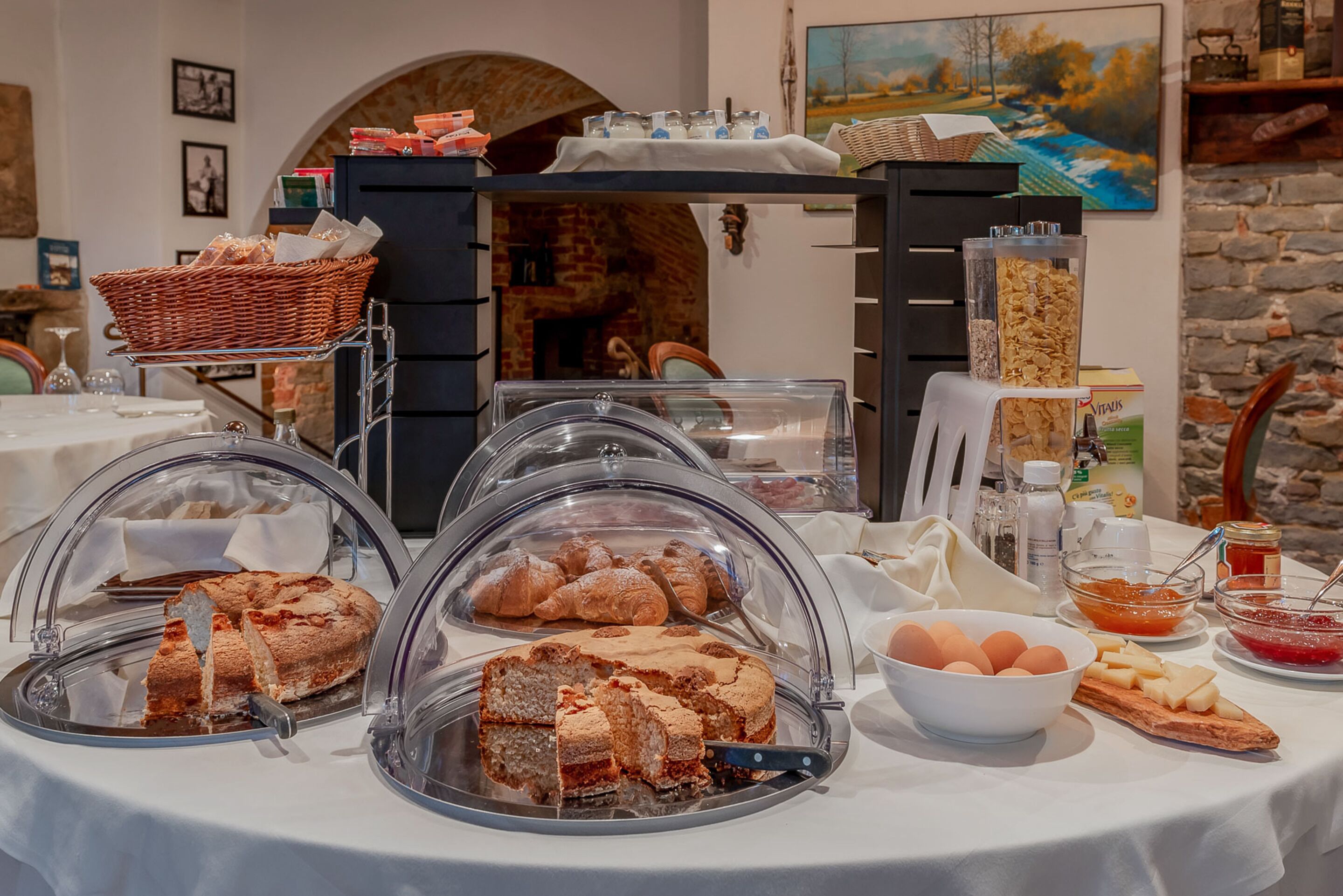 A breakfast buffet with various pastries, bread, and eggs.