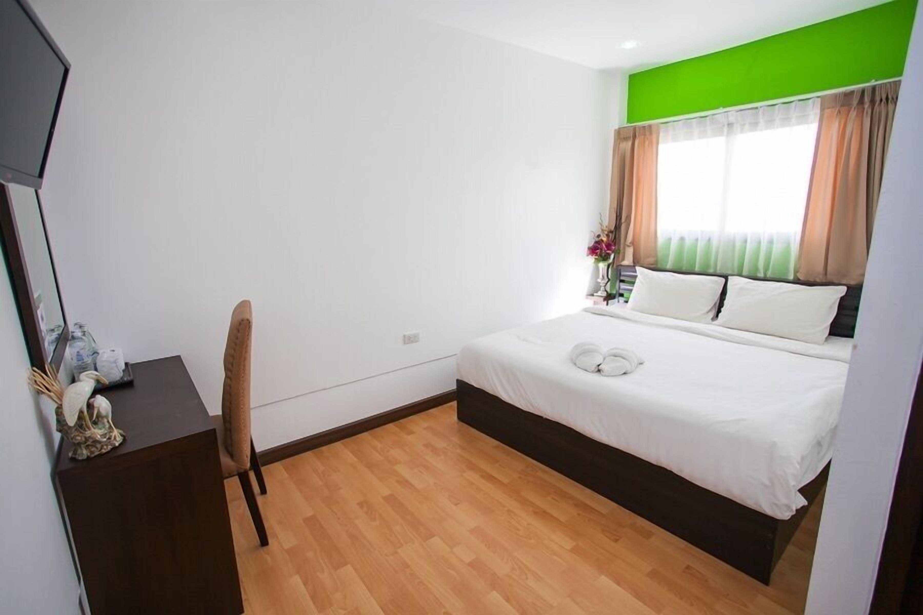 Un dormitorio con una cama, un escritorio y una silla.