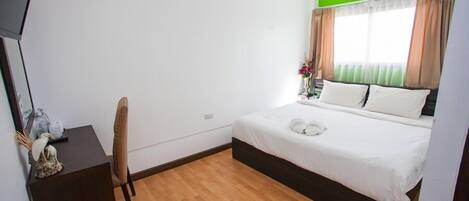 Un dormitorio con una cama, un escritorio y una silla.