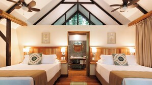A hotel room with two beds, wooden beams, a ceiling fan, a mirror, and a view of the outdoors. - Almonds and Corals Boutique Hotel (Cahuita)