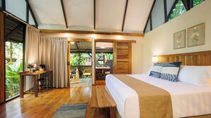 A bedroom with a large bed, wooden furniture, and a view of the outdoors. - Almonds and Corals Boutique Hotel (Cahuita)