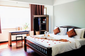 Una camera d'albergo con un letto di legno, una scrivania e un armadio.