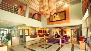 A spacious lobby with a reception desk, seating area, and a large chandelier. - Ramada Georgetown Princess Hotel (Georgetown)
