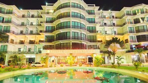 A multi-story hotel with a pool in the foreground. - Ramada Georgetown Princess Hotel (Georgetown)