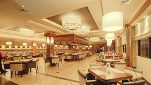 A spacious hotel lobby with multiple dining areas, large chandeliers, and a Christmas tree. - Ramada Georgetown Princess Hotel (Georgetown)