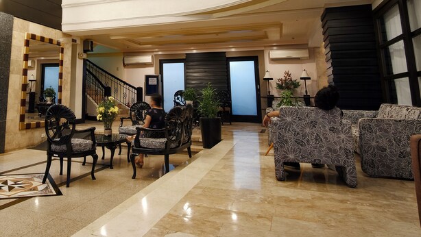 A spacious lobby with a high ceiling, a staircase, and a seating area with patterned sofas. - Fersal Hotel Malakas (Quezon City)